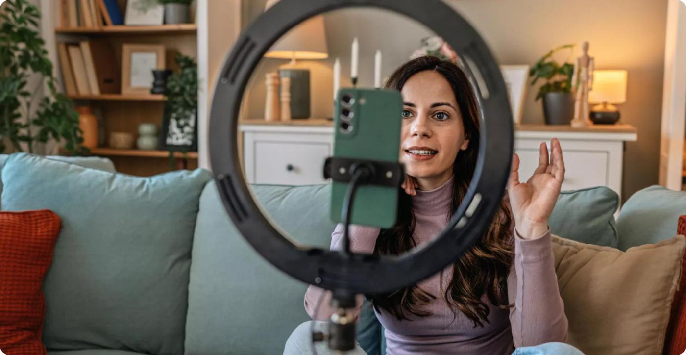 Creator filming a video for social media with a ring light and phone